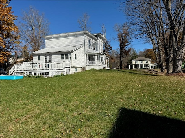 back of property featuring a deck and a yard