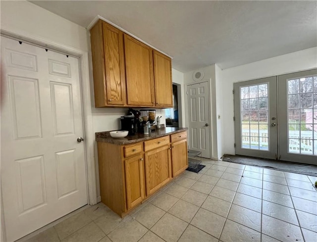 kitchen with dark countertops, brown cabinets, and light tile patterned floors