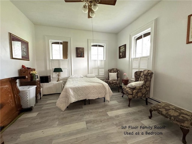 bedroom featuring a baseboard radiator, a ceiling fan, and light wood-style floors