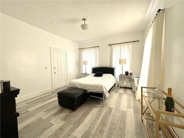 bedroom with light wood-style flooring and baseboards