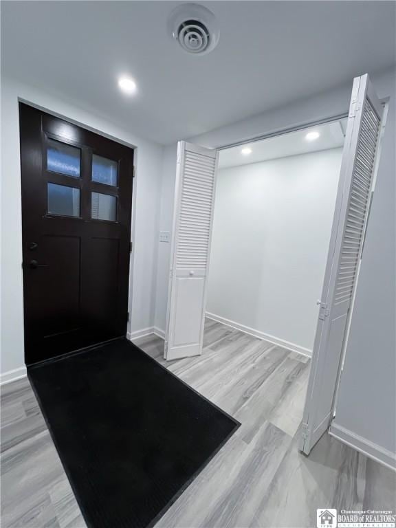 foyer with recessed lighting, visible vents, light wood-style flooring, and baseboards