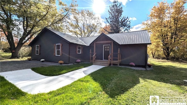 view of front of property featuring metal roof and a front yard