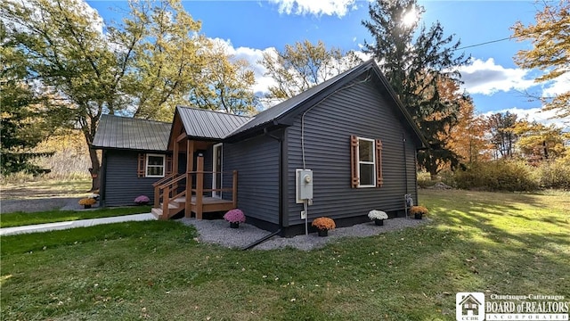 view of front of home with metal roof and a front yard