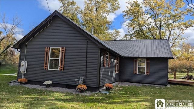 view of property exterior featuring metal roof and a yard