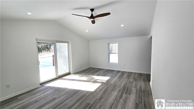 unfurnished room featuring lofted ceiling, dark wood-style flooring, ceiling fan, and baseboards