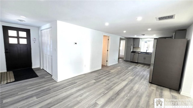 foyer entrance with recessed lighting, light wood-type flooring, visible vents, and baseboards