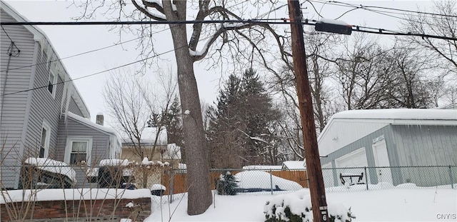 yard covered in snow featuring a fenced front yard