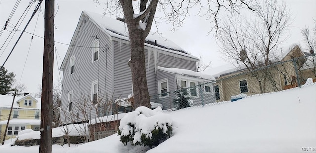 snow covered property featuring fence