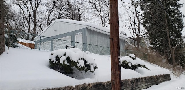 view of snow covered exterior featuring fence