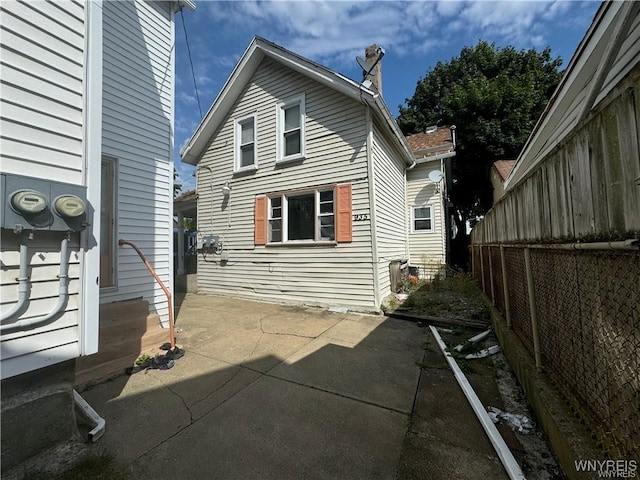 view of property exterior with entry steps, a patio, and fence