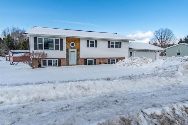 raised ranch featuring a garage and brick siding