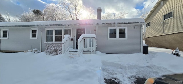 view of snow covered back of property