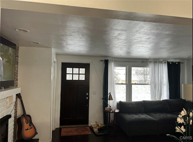 entrance foyer with a textured ceiling and a stone fireplace