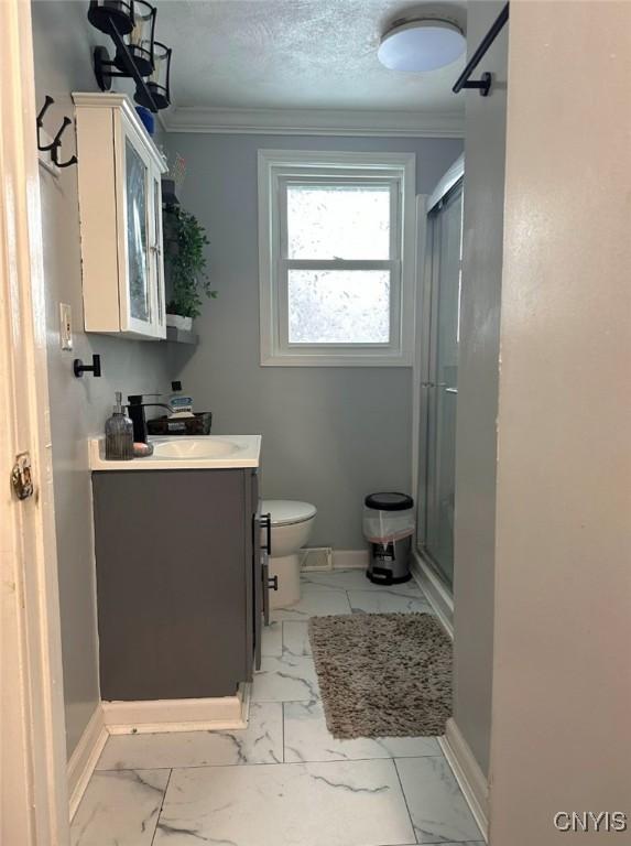 bathroom featuring ornamental molding, marble finish floor, and baseboards