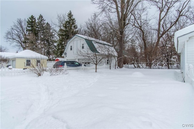 yard layered in snow featuring a garage and fence