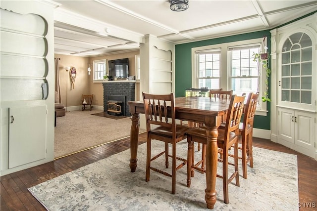 dining room with dark wood-style floors, a brick fireplace, coffered ceiling, and baseboards