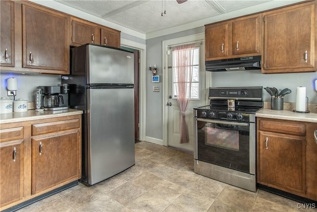 kitchen featuring stainless steel appliances, brown cabinets, light countertops, and under cabinet range hood