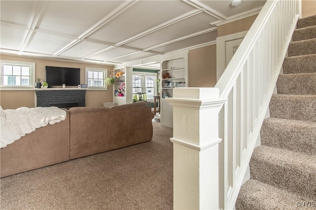 carpeted living area with a fireplace and stairs