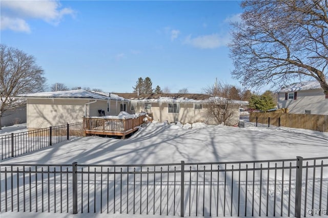 yard covered in snow with fence and a deck