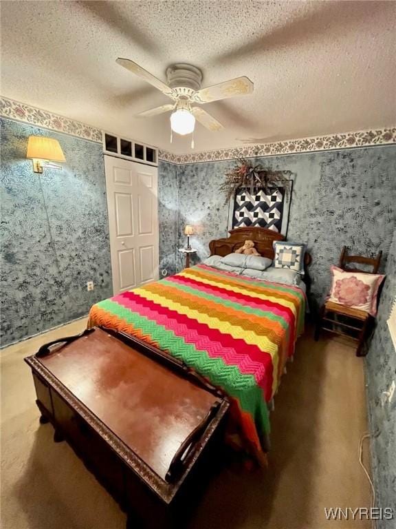 bedroom with carpet floors, ceiling fan, a textured ceiling, and wallpapered walls