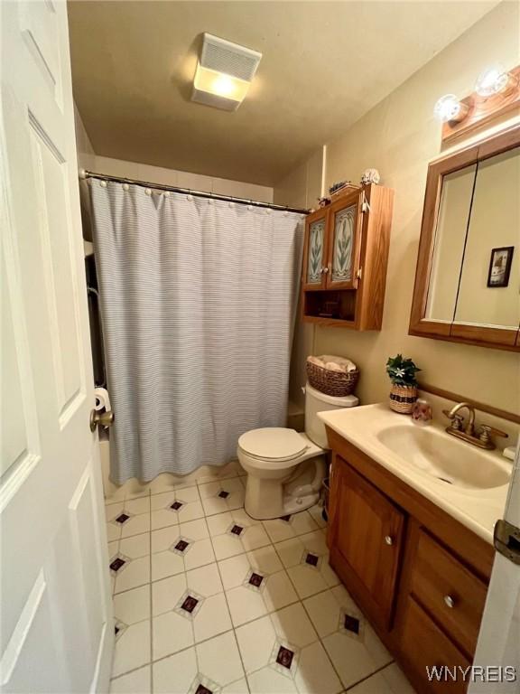 bathroom featuring visible vents, vanity, toilet, and tile patterned floors