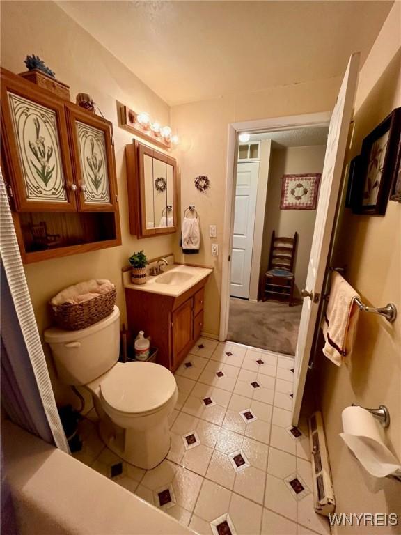 full bathroom with toilet, vanity, and tile patterned floors