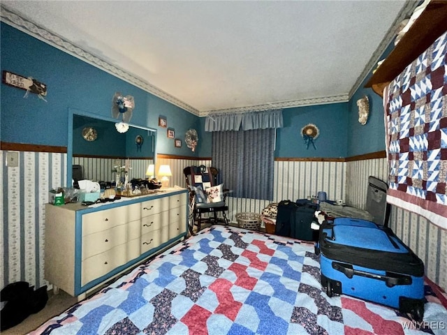 bedroom featuring a wainscoted wall and ornamental molding