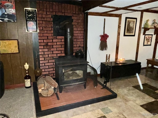 living area featuring a wood stove and wooden walls