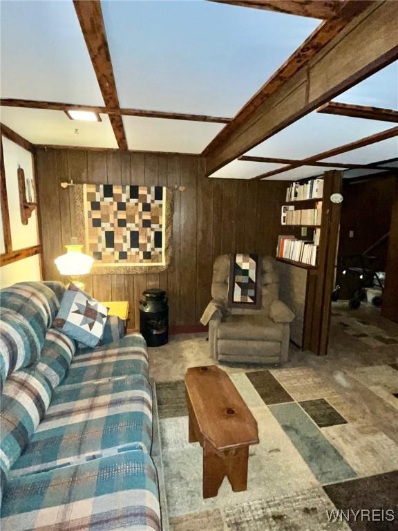 living room featuring beamed ceiling and wooden walls