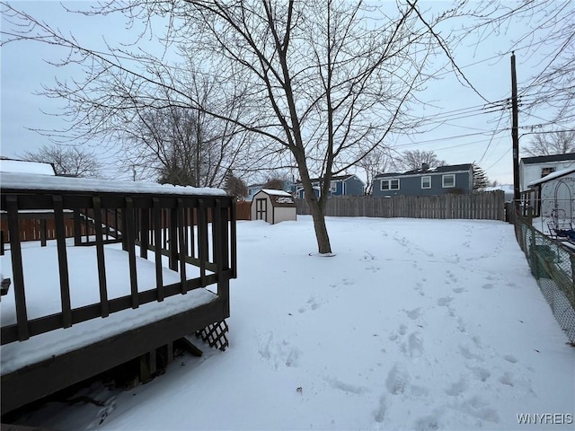 yard covered in snow featuring an outdoor structure, fence, and a shed