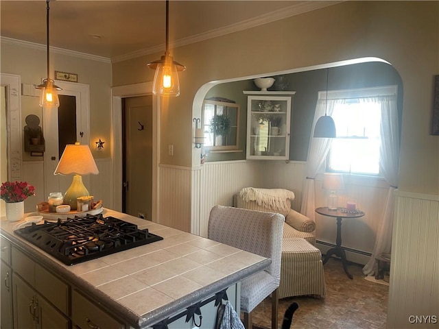 dining area with a baseboard radiator, arched walkways, crown molding, and wainscoting