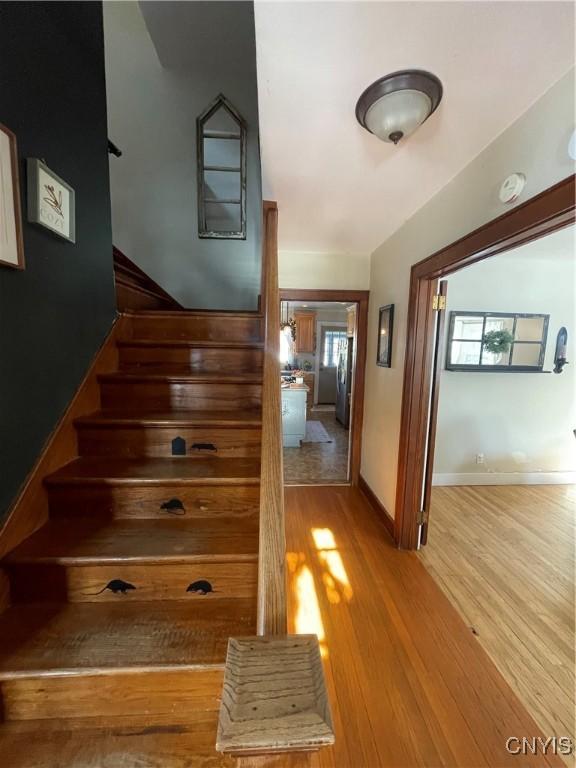 staircase with wood finished floors and baseboards