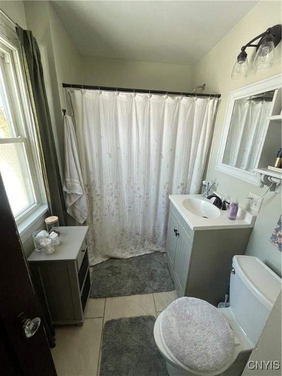 bathroom featuring curtained shower, vanity, toilet, and tile patterned floors