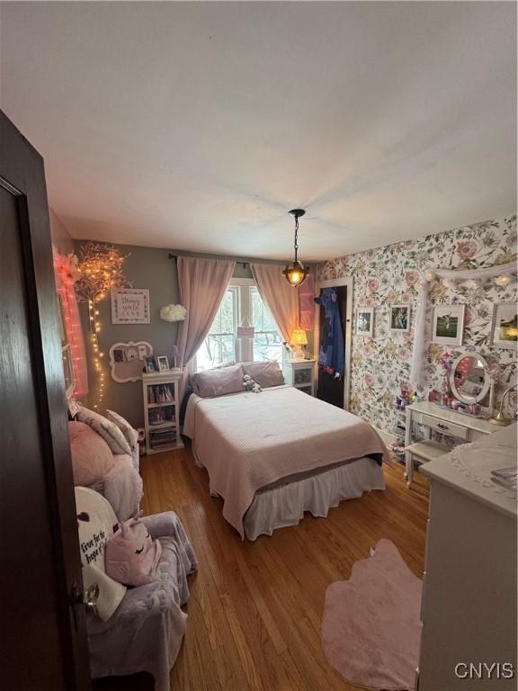 bedroom featuring light wood-type flooring and wallpapered walls