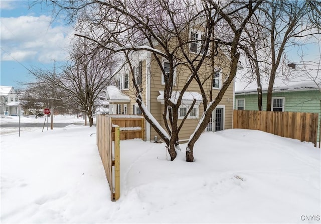 snowy yard featuring fence