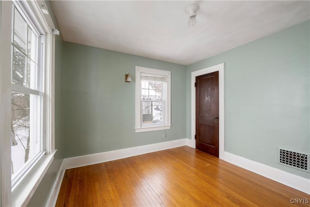 spare room with visible vents, light wood-style flooring, and baseboards