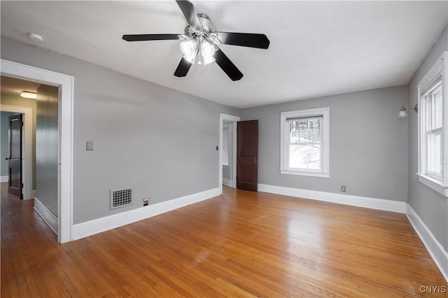 spare room featuring visible vents, light wood-style flooring, and baseboards