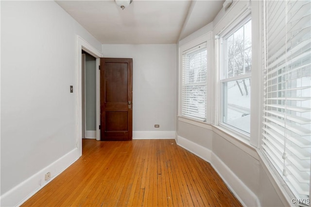 unfurnished room with light wood finished floors and baseboards