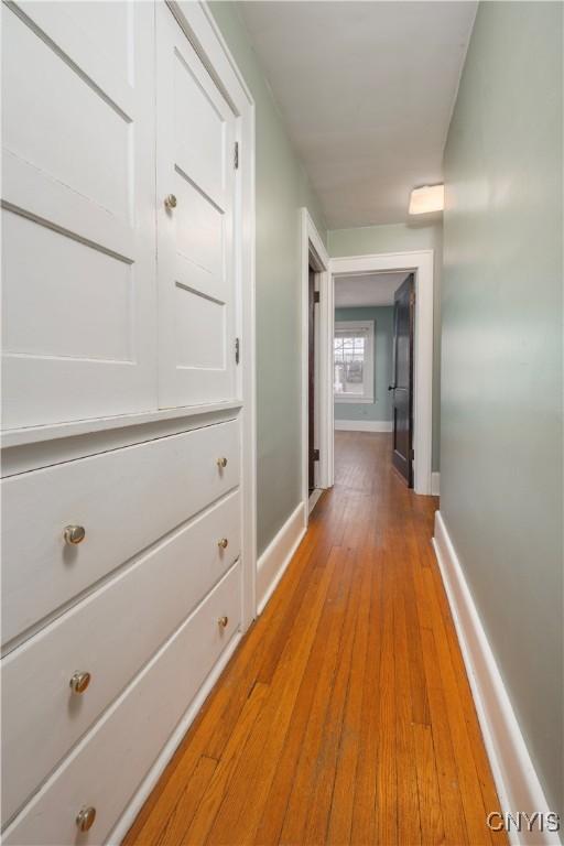 hallway with light wood-style floors and baseboards