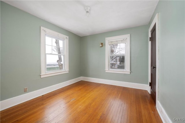 unfurnished room featuring baseboards and wood finished floors