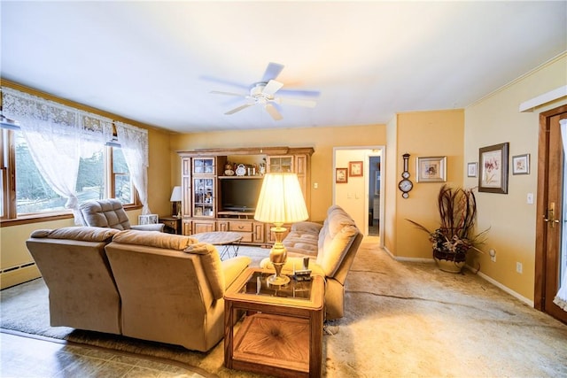 living room featuring baseboards, a ceiling fan, and ornamental molding