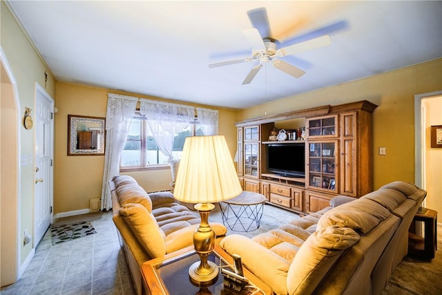 living room with dark tile patterned flooring, ceiling fan, and baseboards