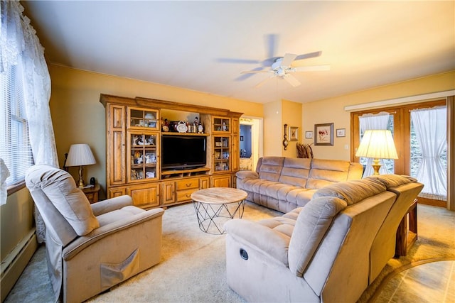 living area with light carpet, ceiling fan, and a baseboard heating unit