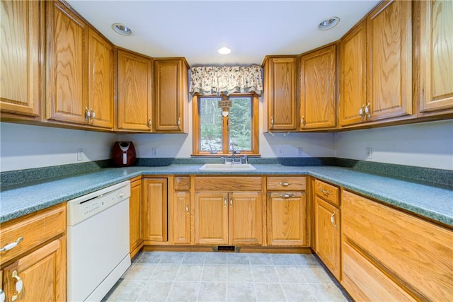 kitchen featuring recessed lighting, a sink, brown cabinets, dishwasher, and dark countertops