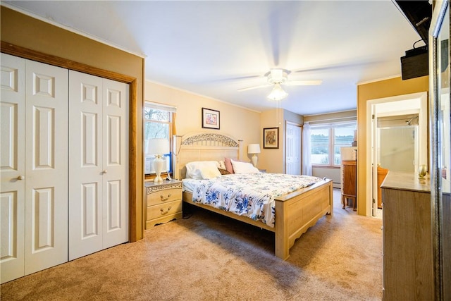 bedroom featuring light carpet, ornamental molding, a closet, and a ceiling fan