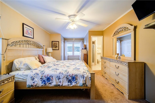 bedroom featuring ceiling fan, dark colored carpet, ensuite bath, and crown molding