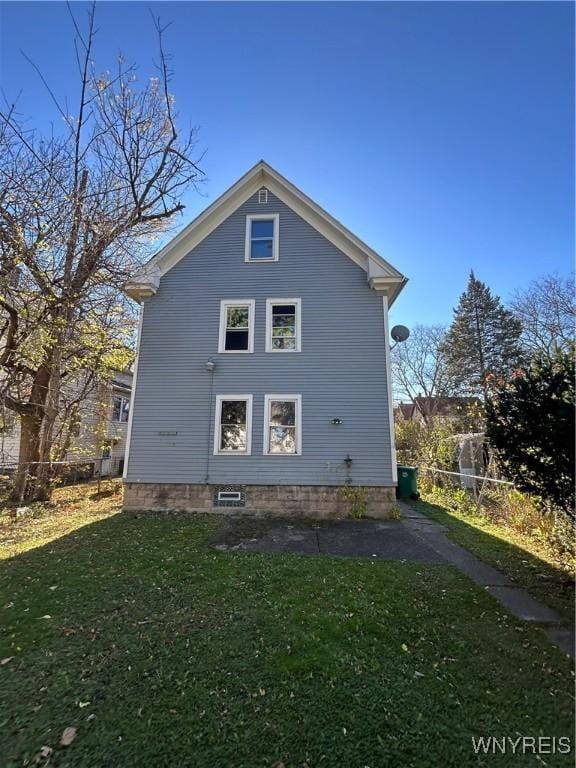 view of side of home featuring fence and a yard