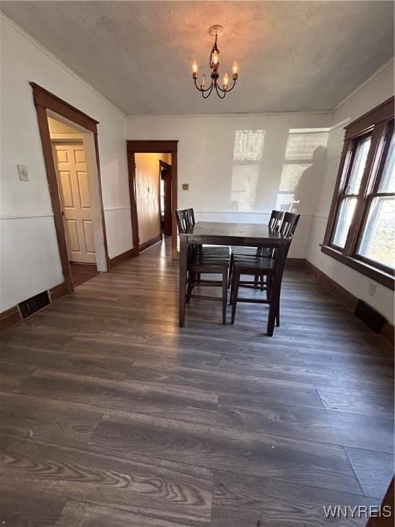 dining space with dark wood-style flooring, visible vents, a notable chandelier, and baseboards