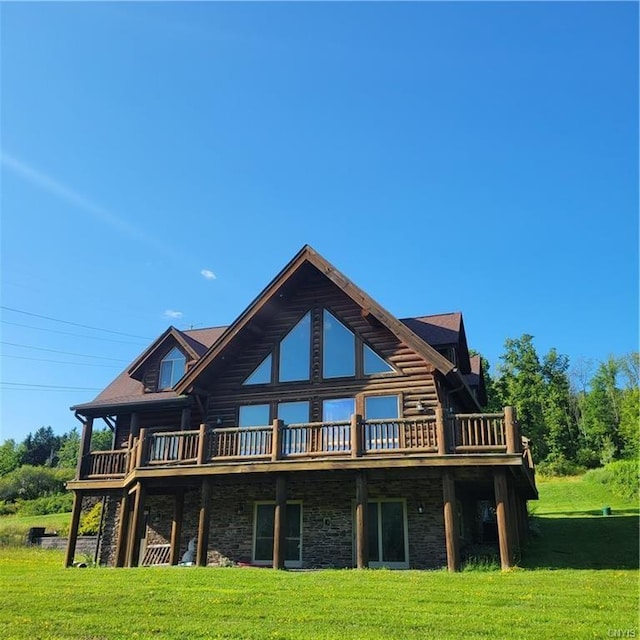 rear view of house with stone siding, log siding, a lawn, and a wooden deck