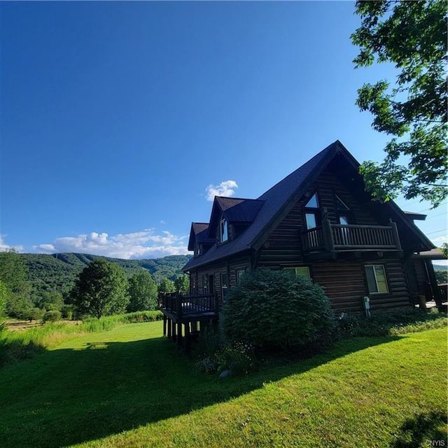 view of property exterior with a deck and a lawn